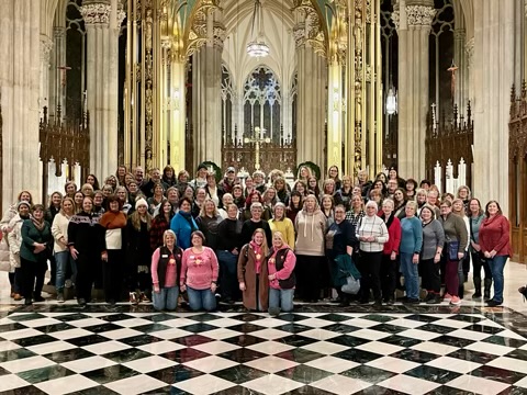 Bus tour group at the high altar with white roses
